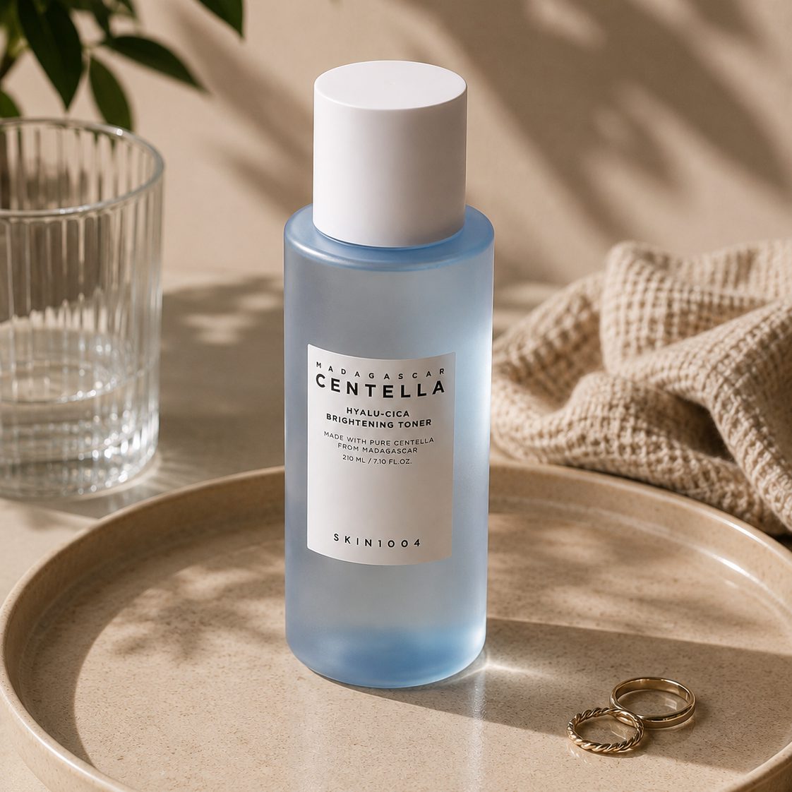 The bottle on a ceramic tray beside a glass